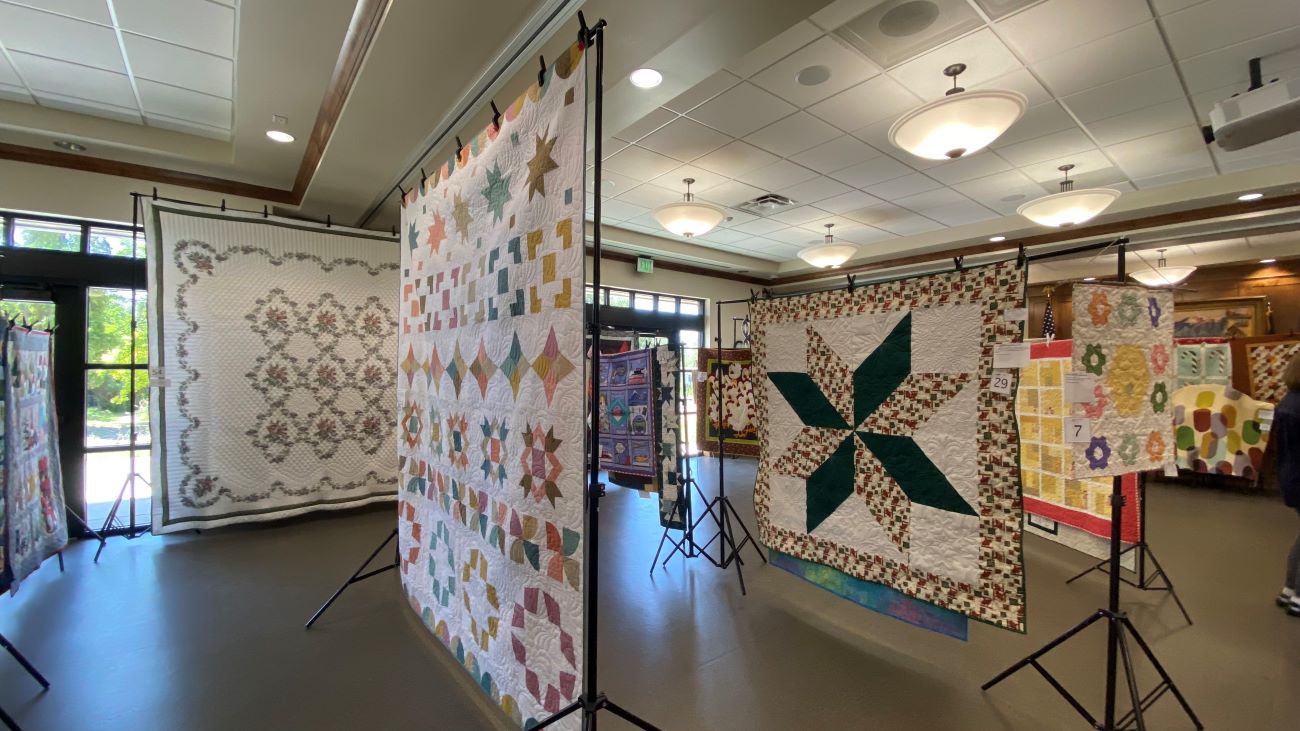 Multiple quilts hanging at the Nibley Town Hall in Utah as part of their Heritage Days celebration.
